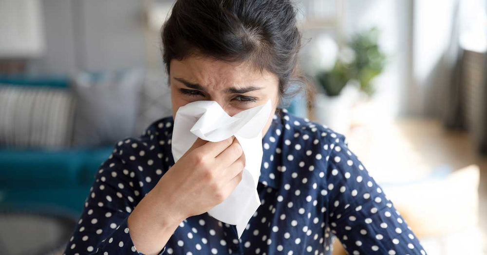 Woman with allergies blowing her nose