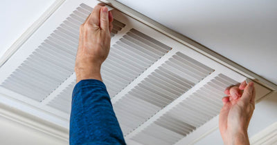 Man pulling open overhead vent door