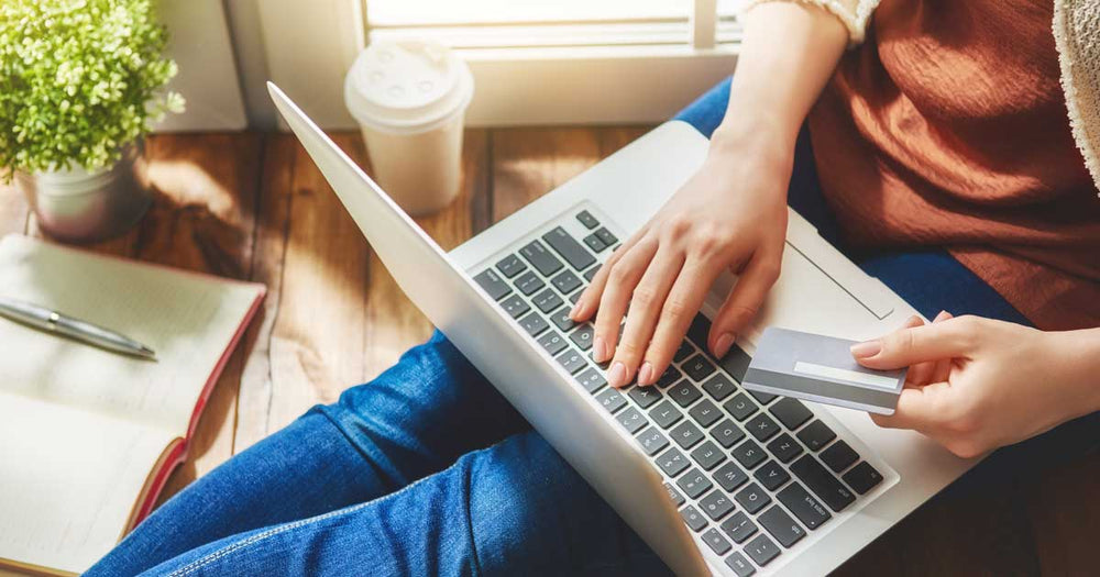Woman sitting with her laptop holding her credit card