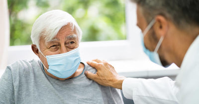 Elderly man wearing surgical mask with his physician