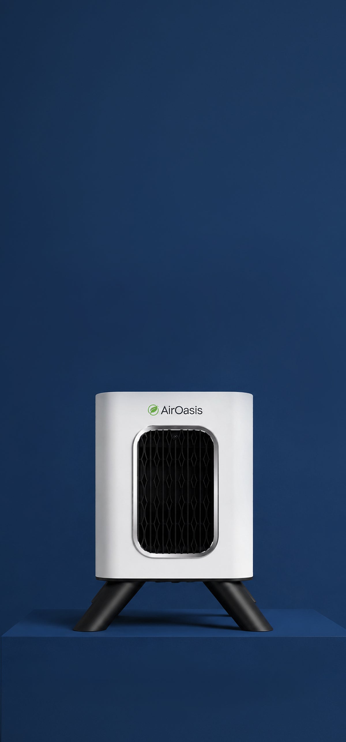 A compact white AirOasis portable air purifier with a black front grille and black tripod-style feet, standing on a matching blue pedestal against a dark blue background.