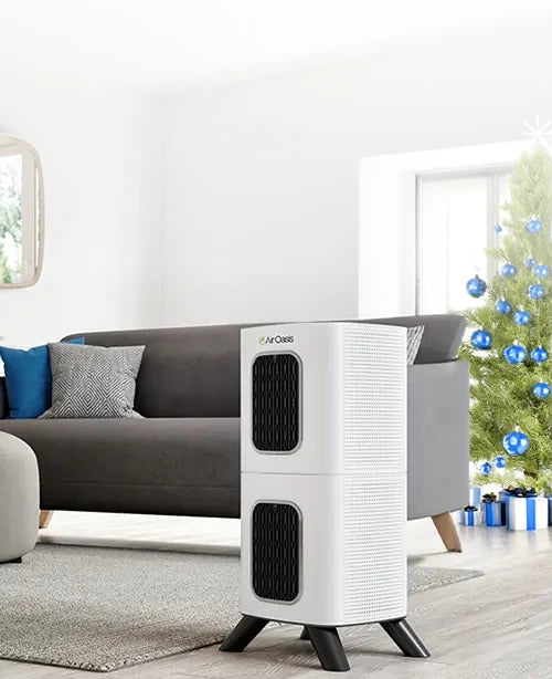 Modern white air purifier on a living room floor with a Christmas tree in the background
