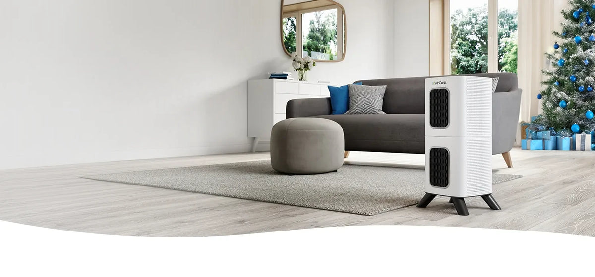 White and black air purifier on a wooden floor in a modern living room.